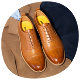 The Cap-Toe in Honey top down photo on top of dress clothes