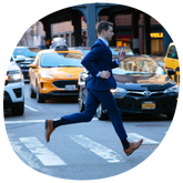 The Cap-Toe in Honey worn by model paired with blue suit running across the street