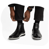 Model adjusting pants wearing black and white amberjack chelsea boots